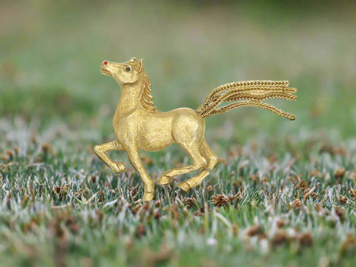 Discover the exquisite craftsmanship of this vintage horse brooch and its intricate design, from lifelike features to the vibrant red enameled nostrils. 