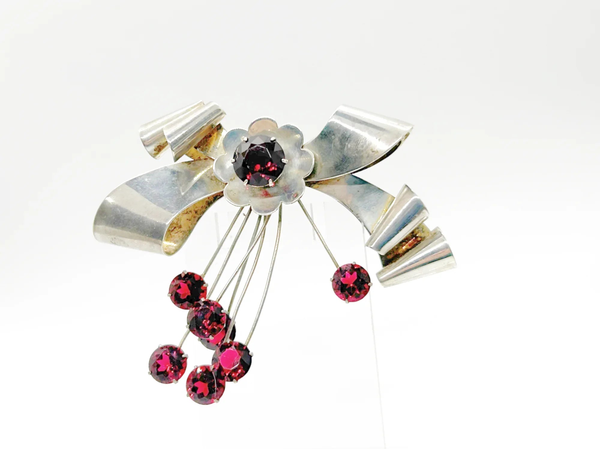 Perfect for vintage jewelry lovers: our Sterling by Jordan 1940s Red Stone Vintage Bow Brooch provides timeless elegance with striking red stones. Shop today!