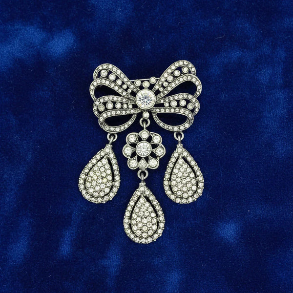 This exquisite piece of jewelry, crafted by Kenneth Jay Lane, is a shimmering testament to the exquisite beauty of the 18th century. It is dazzling, with crystal studded bows and gracefully dangling elaborate teardrops.