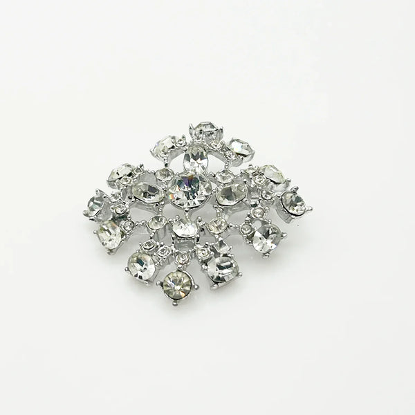This splendid vintage rhinestone brooch made in a lacy design of bright white round and oval rhinestones. The setting is silver tone metal and measures 1 1/2" wide. The condition is very good. It can be worn sideways or vertically, and looks wonderful either way. The stones have excellent fire and clarity, full of eye catching glitter.