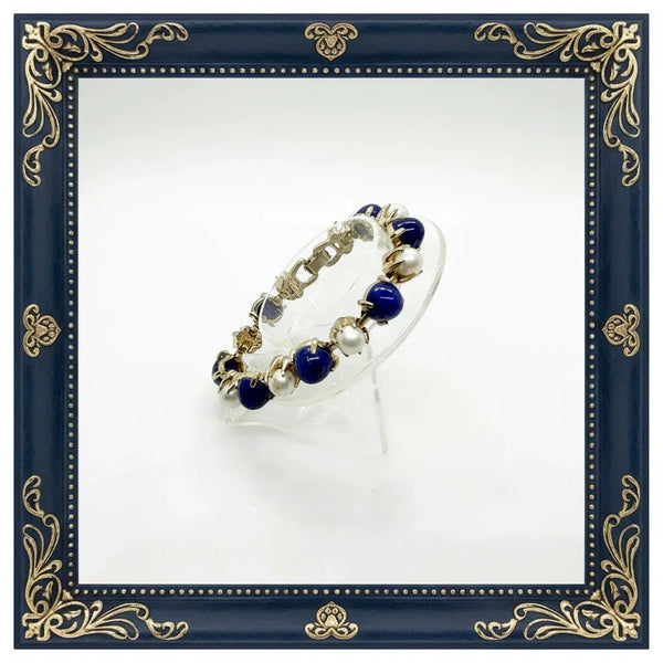 This exquisite vintage bracelet combines timeless elegance with striking visual appeal. Featuring alternating domed lapis-style stones in rich deep blue tones paired with lustrous faux pearls, all set in warm gold-tone metal, it's a statement piece that elevates any ensemble.