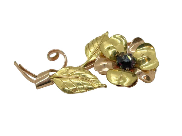 Bring a touch of vintage glamour to any outfit with this stunning, handmade flower brooch. Its beautifully crafted copper and gold petals and leaves surround a sparkling purple center, making it a striking statement piece that will surely turn heads.