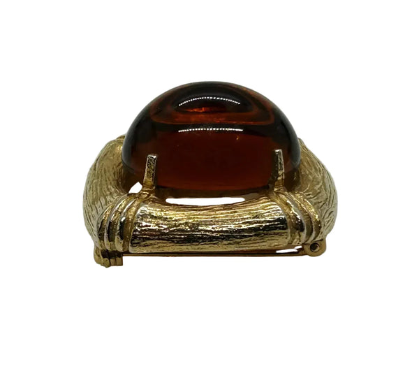 Indulge in the warm, honeyed glow of this delightful Les Bernard brooch. Rich amber glass catches the light like liquid caramel, nestled within a brushed gold-tone squared setting that frames it to perfection.
