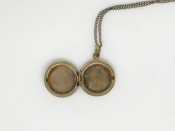 he locket has enough space for two treasured photos or any other keepsake of your choice. Measuring .75" in diameter, it comes with a delicate 17" chain to elevate your look. It has wear on the back appropriate for its age. P