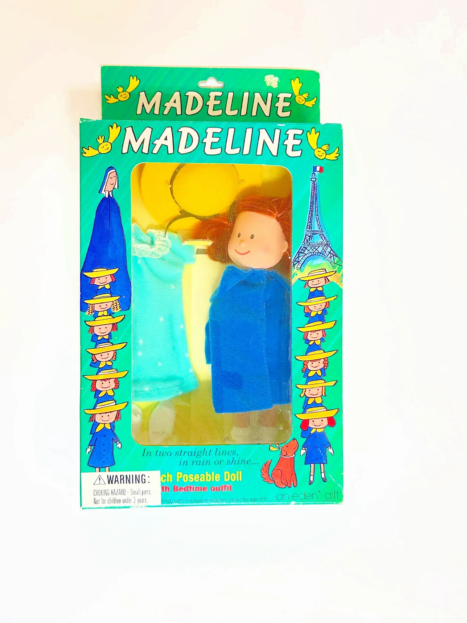 From Eden Toys, Inc., comes this 8" poseable Madeline doll, complete with her school dress, blue coat, socks, shoes, pantes and iconic yellow hat. night clothes. Attention to detail shows in the appendix scar described in the books and fully combable hair. She also has a change of night clothes, a blue nightgown and white slippers.