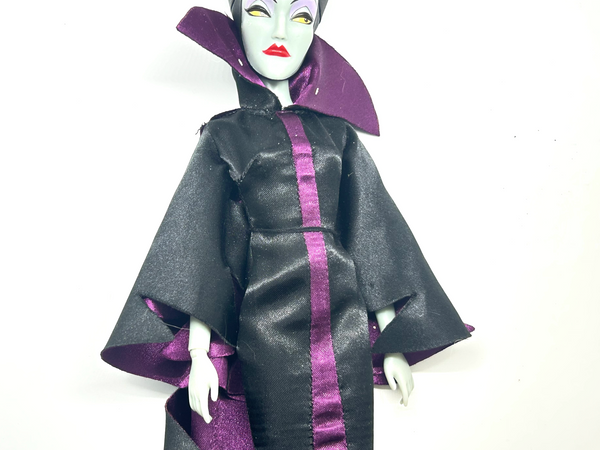 Disney Store Maleficent 12-inch classic fashion doll wearing her iconic black and burgundy robe with curved horns headpiece, isolated on a solid white background.