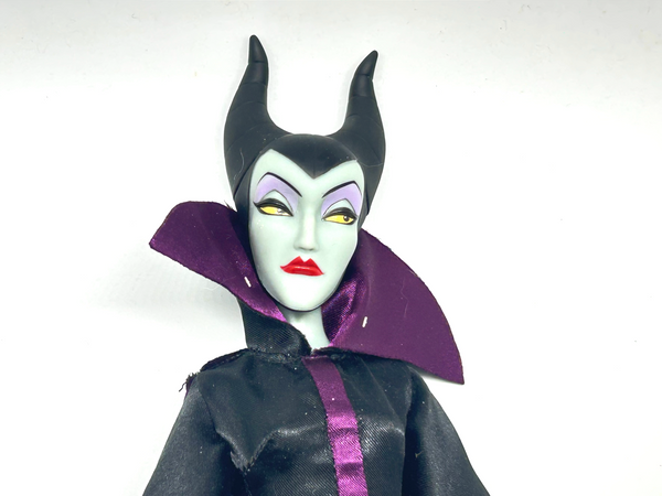 Disney Store Maleficent 12-inch classic fashion doll wearing her iconic black and burgundy robe with curved horns headpiece, isolated on a solid white background.