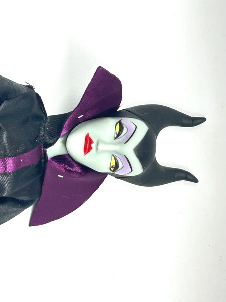 Disney Store Maleficent 12-inch classic fashion doll wearing her iconic black and burgundy robe with curved horns headpiece, isolated on a solid white background.
