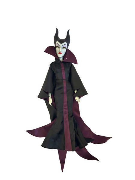 A doll or figurine dressed as Maleficent, wearing a long black gown with a deep burgundy center panel and matching dark burgundy collar, plus a black horned headpiece, photographed against a plain white background.