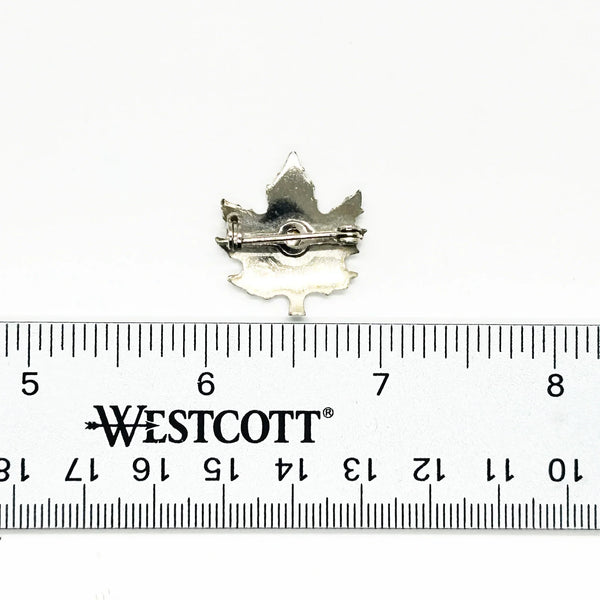 Add a touch of vintage charm to your wardrobe with this delightful silver maple leaf pin! This little beauty- measuring just 1" across- showcases intricate etching that brings the iconic leaf to life, complete with a textured finish that catches the light beautifully.