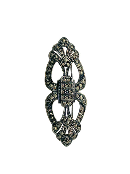Vintage Art Deco sterling silver bar brooch featuring an openwork geometric design inlaid with shimmering marcasite stones, isolated on a white background.