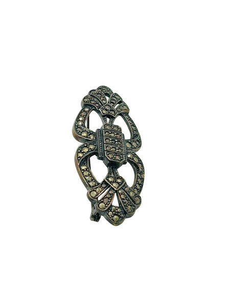 Vintage Art Deco sterling silver bar brooch featuring an openwork geometric design inlaid with shimmering marcasite stones, isolated on a white background.