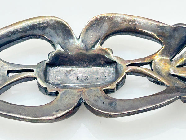 Vintage Art Deco sterling silver bar brooch featuring an openwork geometric design inlaid with shimmering marcasite stones, isolated on a white background.