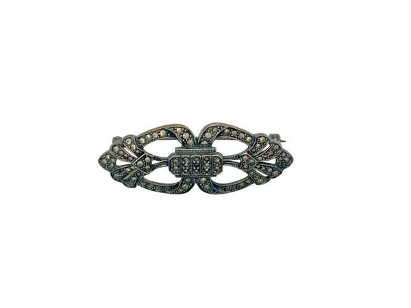 Vintage Art Deco sterling silver bar brooch featuring an openwork geometric design inlaid with shimmering marcasite stones, isolated on a white background.