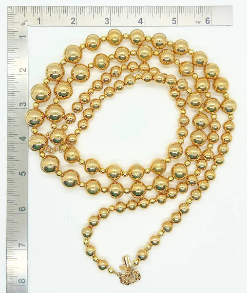 Striking and Dramatic, this gold bead double strand necklace is signed Marvella and measures 25” and 26" with a hook clasp, slight wear to clasp