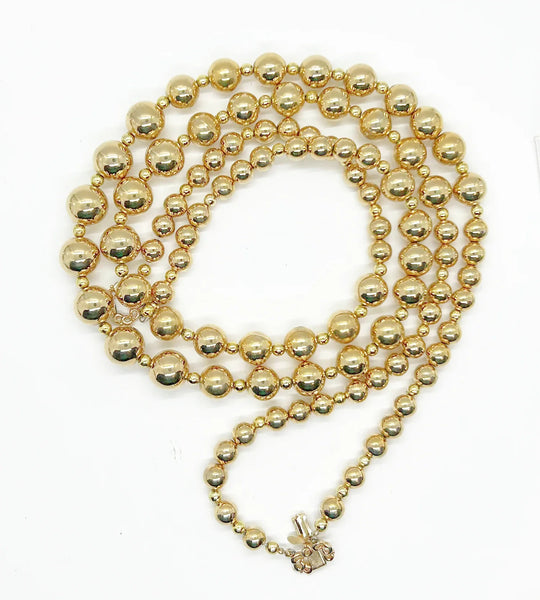 Striking and Dramatic, this gold bead double strand necklace is signed Marvella and measures 25” and 26" with a hook clasp, slight wear to clasp