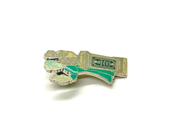 This pin is a 2012 Disney Parks Walt Disney World Haunted Mansion Interactive Graveyard Queue "Cousin Maude and Uncle Jacob's Statue" mystery pin.