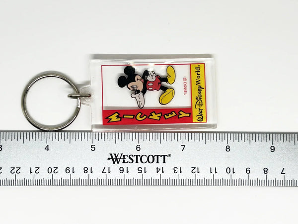 This Mickey Mouse keychain perfectly shows off Mickey's exuberant and friendly spirit. It is made of clear acrylic, and shows Mickey in his trademark red shorts with white buttons, white gloves and yellow shoes. He smiles broadly and extends a welcoming hand- the classic depiction of Mickey.