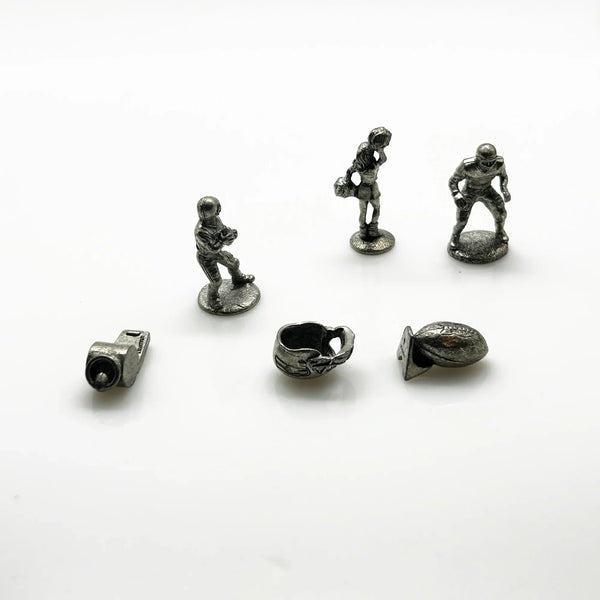 These are pewter tokens from a NFL Collector's Edition of the Monopoly board game, such as the 1998 or 2004 version.;The set includes miniature pewter figures of football players, a cheerleader, a football helmet, a football, and a whistle. I believe they were the Seattle Seahawks version.They are popular replacement parts for enthusiasts collecting specific themed Monopoly sets.