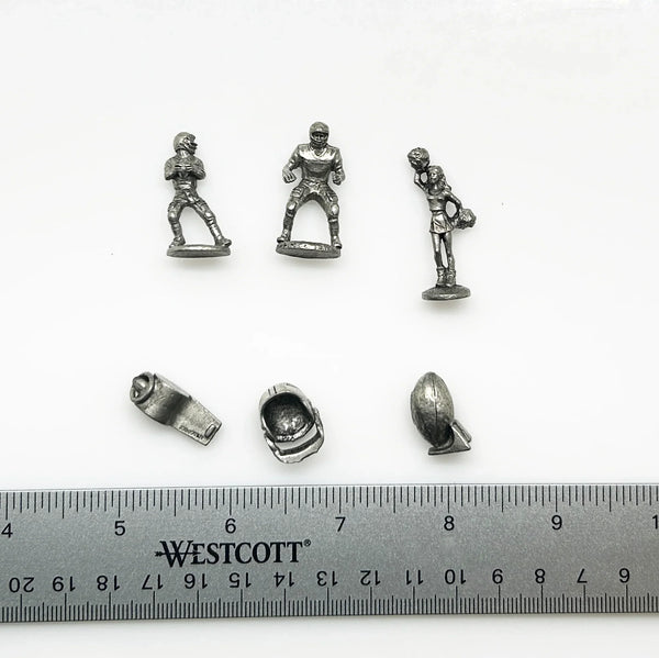 These are pewter tokens from a NFL Collector's Edition of the Monopoly board game, such as the 1998 or 2004 version.;The set includes miniature pewter figures of football players, a cheerleader, a football helmet, a football, and a whistle. I believe they were the Seattle Seahawks version.They are popular replacement parts for enthusiasts collecting specific themed Monopoly sets.