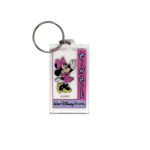 This Minnie Mouse keychain is too cute. It is made of clear acrylic, and shows Minnie Mouse in a pink dress, a pink bow, white gloves and yellow shoes. She has a big smile and is waving. The letters on the left side read "Minnie" in lavender with black border, on a bright pink background. Below Minnie is a purple banner with "Walt Disney World" in black