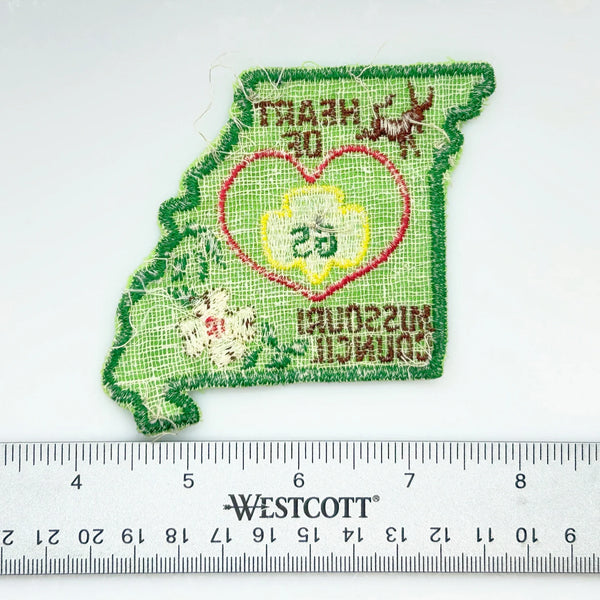 Embroidered patch of Missouri with Girl Scout logo on a white background