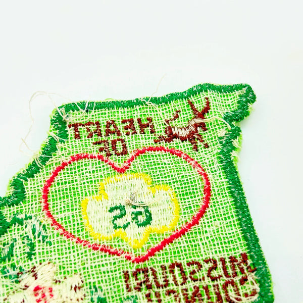This authentic vintage shoulder patch celebrates the Heart of Missouri Girl Scout Council, once based in Jefferson City and Columbia. The distinctive Missouri-shaped design features a prominent pink heart showcasing the iconic Girl Scout "GS" logo at its center. 