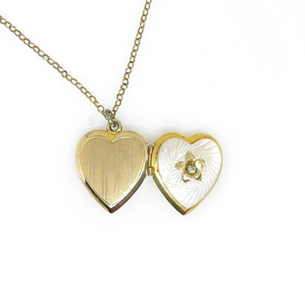 Mother of Pearl Heart Locket Necklace - Timeless vintage locket with a mother-of-pearl face and enamel flower detail. Heart-shaped and perfect for keepsakes. Shop now!