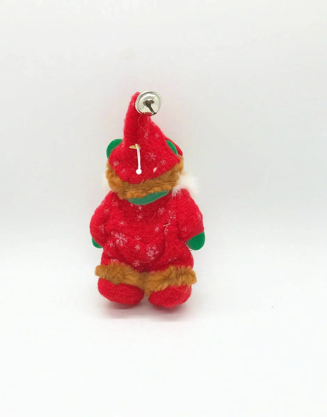 A small plush Christmas gnome ornament wearing a red outfit with green accents, a white beard, and a brown hat.