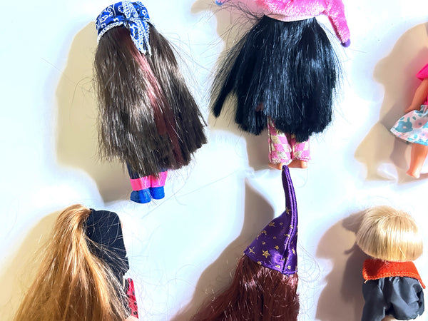 A collection of nine vintage Mattel Barbie Kelly Club 4-inch miniature dolls shown from the back against a white background. The assortment features dolls in various costumes and outfits, including a red-and-black spotted ladybug, a yellow-and-black striped bumblebee with wings, a plush white panda suit, a doll wearing a pink top and patterned blue skirt, and several figures with colorful hair and long wizard or witch hats