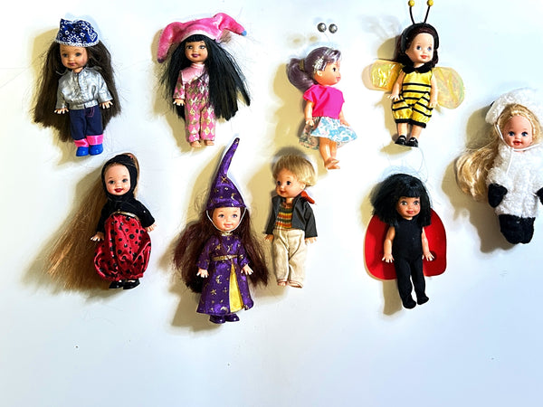 A lot of vintage mixed Mattel Kelly Club and Li'l Friends of Kelly 4-inch mini dolls in costume outfits, showcasing Biker Belinda in a silver jacket, Wizard Melody in a purple star robe, plus bee, ladybug, and lamb plush suits