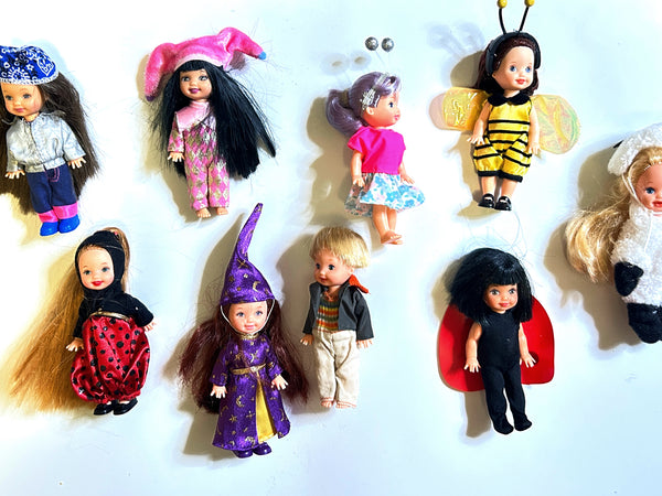 A lot of vintage mixed Mattel Kelly Club and Li'l Friends of Kelly 4-inch mini dolls in costume outfits, showcasing Biker Belinda in a silver jacket, Wizard Melody in a purple star robe, plus bee, ladybug, and lamb plush suits