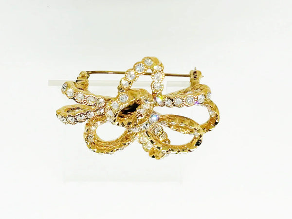Discover a rare glamour brooch by Nolan Miller, a super sparkly 3D ribbon design in rich gold metal with bright clear stones. Free shipping included!
