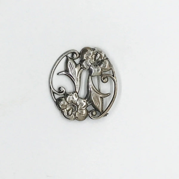 This stunning Art Nouveau floral brooch captivates with two beautiful blooms in an elegant oval shape. 