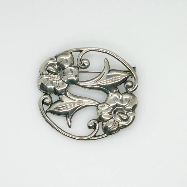 This stunning Art Nouveau floral brooch captivates with two beautiful blooms in an elegant oval shape. 