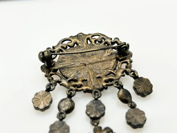 Level up your vintage jewelry collection with this stunning coral-hued brooch that captures timeless elegance. The piece showcases a luminous pale melon-orange centerstone framed by delicate star-shaped accents and peachy rhinestones that catch the light beautifully.