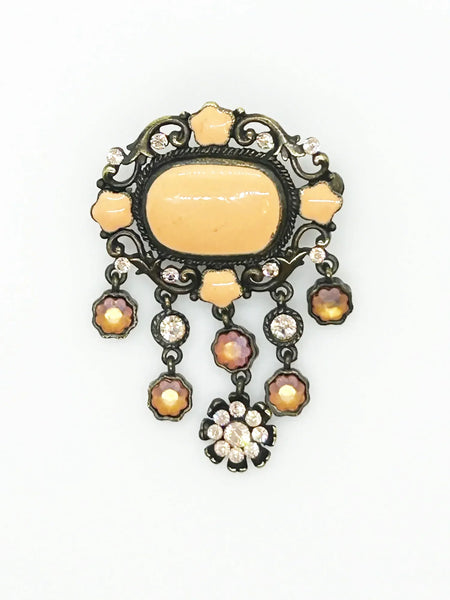 Level up your vintage jewelry collection with this stunning coral-hued brooch that captures timeless elegance. The piece showcases a luminous pale melon-orange centerstone framed by delicate star-shaped accents and peachy rhinestones that catch the light beautifully.
