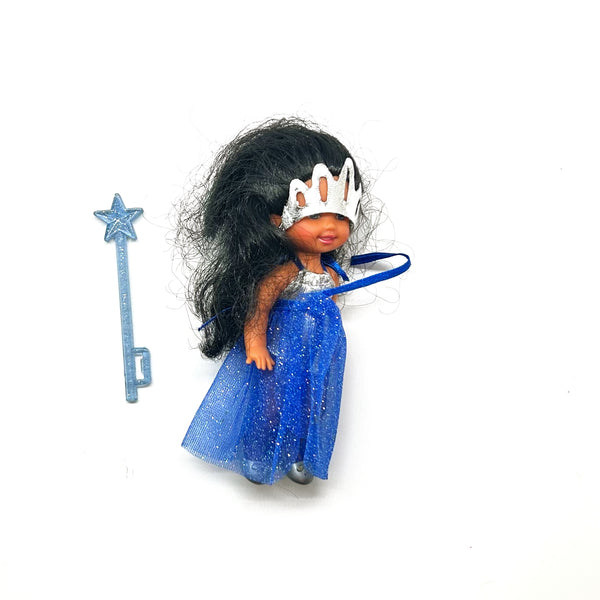 Vintage 2000 Mattel Kelly Club Performer Maria doll with long black hair, wearing her original sparkly blue circus dress and silver tiara, posed next to a blue star wand against a white background