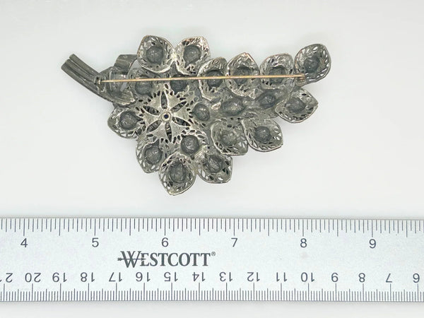 This exquisite vintage pewter tone blue rhinestone floral brooch boasts dimensions of 4" by 2.25" and features three stems and a partial bow. 