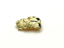 A vintage DKI gold-tone enamel brooch shaped like two snuggling black and white spotted pigs on a white background.