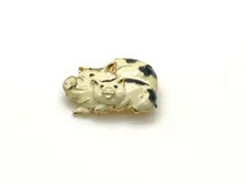 A vintage DKI gold-tone enamel brooch shaped like two snuggling black and white spotted pigs on a white background.