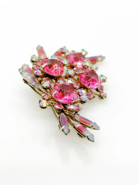 Add a touch of unique style and vibrance to any outfit with this stunning vintage pink brooch. Featuring a captivating design of four layers and various shades of pink stones, including a vibrant round faceted pink stone at the center of each section. It is surrounded by round pink iridescent and vivid stones, as well as several striped watermelon marquise cabochon stones for a unique finishing touch.