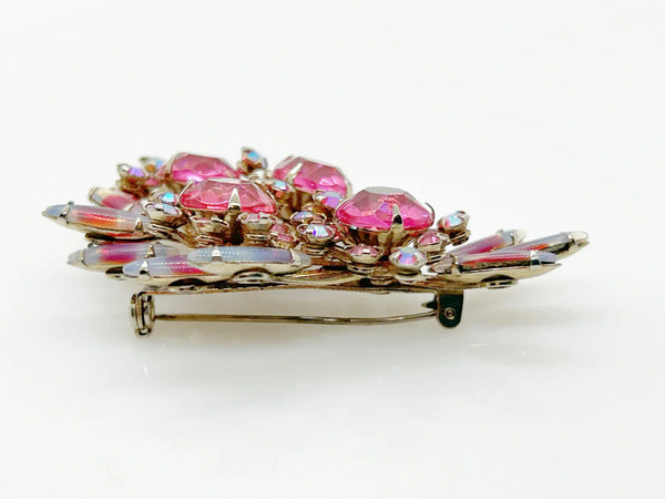 Add a touch of unique style and vibrance to any outfit with this stunning vintage pink brooch. Featuring a captivating design of four layers and various shades of pink stones, including a vibrant round faceted pink stone at the center of each section. It is surrounded by round pink iridescent and vivid stones, as well as several striped watermelon marquise cabochon stones for a unique finishing touch.