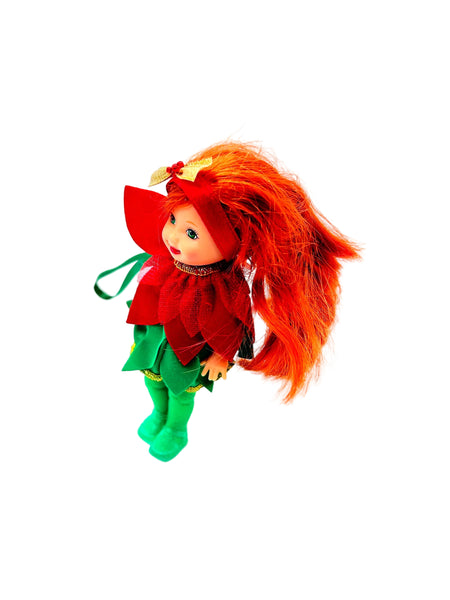 This charming Kelly Club figure features vibrant red hair, festive green tights, and an adorable poinsettia-themed dress that captures the spirit of the season