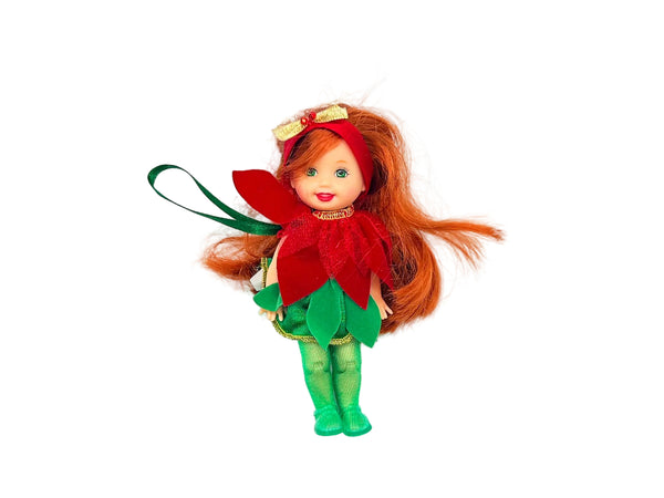  This charming Kelly Club figure features vibrant red hair, festive green tights, and an adorable poinsettia-themed dress that captures the spirit of the season
