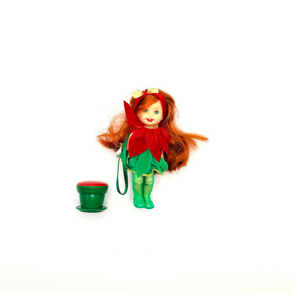 2001 Mattel Barbie Kelly Club Poinsettia Jenny doll ornament next to its green flowerpot stand
