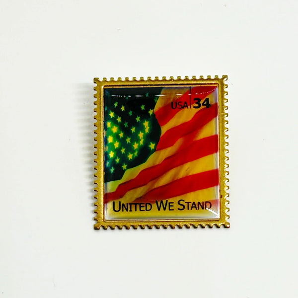 Pin with American flag design and 'United We Stand' text on a white background