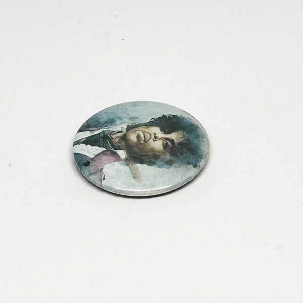 A vintage 1984 Prince pinback button badge featuring a painted portrait of Prince Rogers Nelson during the Purple Rain era