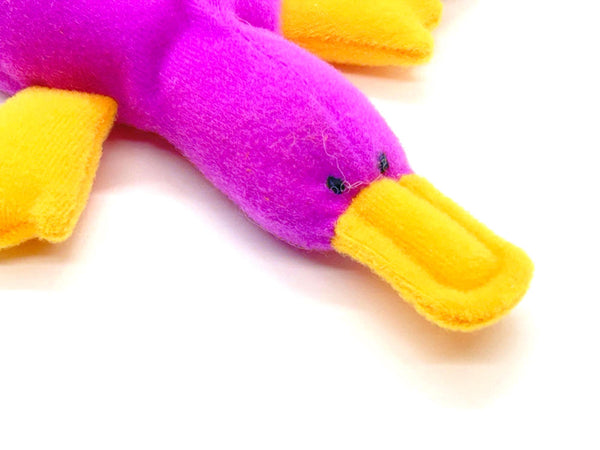 Close-up of a purple and yellow plush toy on a white background