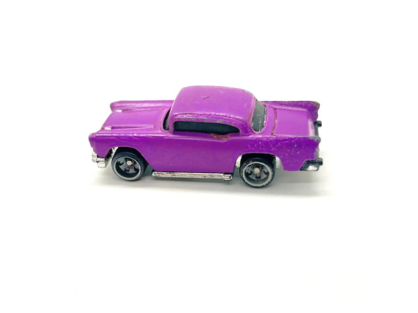 A vintage-style purple toy car with black wheels and silver trim, photographed on a plain white background.